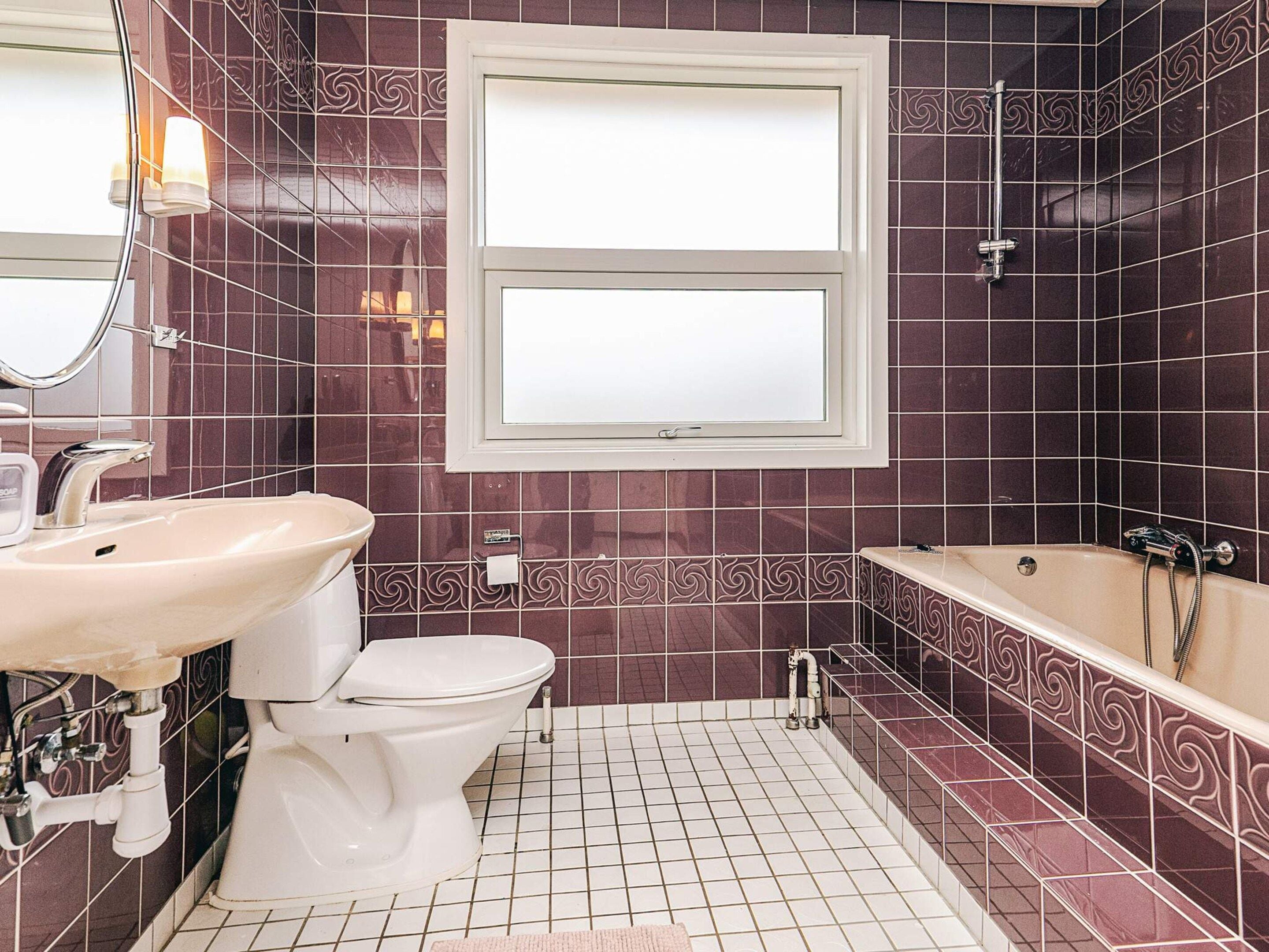 A bathroom with a white toilet, a sink, and a bathtub.