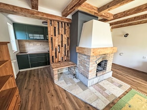 A kitchen with wooden beams, a built-in oven, and a stone floor. - Wonderful private villa for 7 people with WIFI, TV and pets allowed (Chodov)