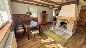 A rustic interior with a wooden dining table, chairs, a fireplace, and a large window. - Stunning private villa for 7 people with WIFI, TV and pets allowed (Chodov)