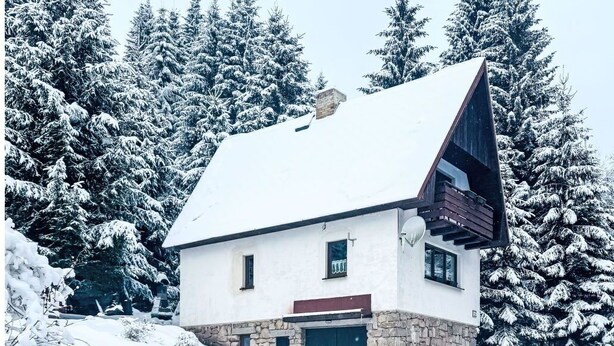 A snow-covered house with a stone foundation, a steep roof, and a satellite dish. - Stunning private villa for 7 people with WIFI, TV and pets allowed (Chodov)