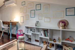 Ein Zimmer mit Schreibtisch, Regalen und Zitaten an der Wand.