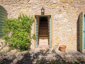 Un bâtiment en pierre avec un escalier menant à une porte portant le numéro 50.