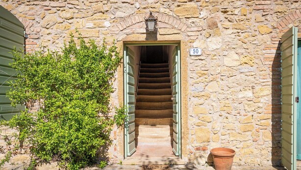 A stone building with a staircase leading to a door marked with the number 50. - Lovely apartment for 5 people with WIFI, patio and pets allowed (Riparbella)