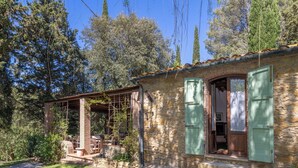 A stone house with a covered patio, a wooden door, and a green shuttered window. - Lovely apartment for 5 people with WIFI, patio and pets allowed (Riparbella)