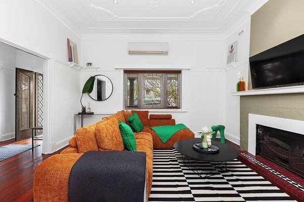 Vibrant & Vacation-Ready! Our living room features an oversized burnt orange sectional—the perfect colorful spot to unwind and recharge.