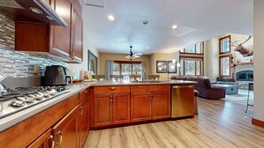 Una cocina amplia con armarios de madera, una isla central y un ventanal grande.