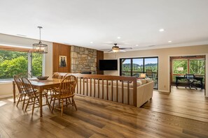 Una cocina moderna con una pared de acento de piedra, una mesa de comedor de madera y sillas.
