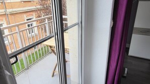 A room with a window overlooking a balcony with a wooden table and chairs. - Beautiful Vacation Rental in Dresden (Dresden)
