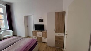 A bedroom with a bed, a wardrobe, a television, and a desk. - Beautiful Vacation Rental in Dresden (Dresden)