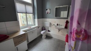 Un baño con inodoro, lavamanos y ventana.