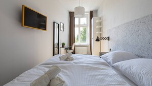 A hotel room with a bed, a desk, a chair, a window, and a television. - Pok j Verde 2 Prywatna Azienka Blisko Star wki (Gdańsk)