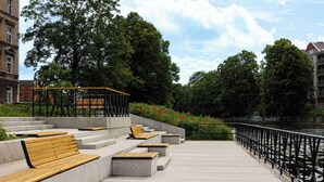 A riverside walkway with benches, a metal railing, and steps leading down to the water. - Verde 5 Gda sk Pok j z Azienk Blisko Centrum (Gdańsk)