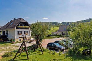 Ein Haus mit geneigtem Dach, einer Holzwentil und einem Auto auf der Auffahrt.