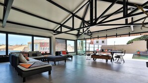 Amplia sala de estar con techos altos, ventanas grandes y vistas a la ciudad.