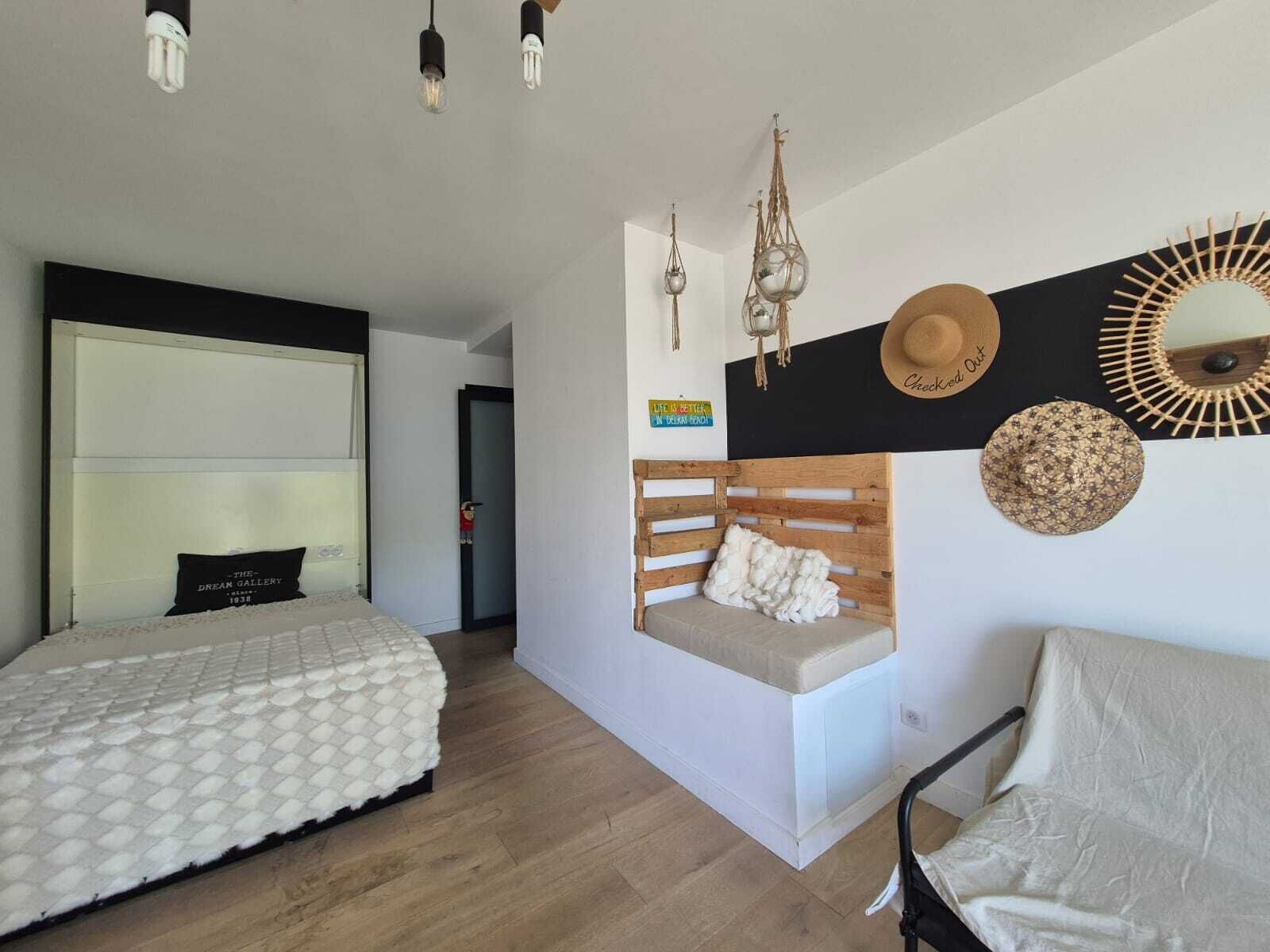 Una camera da letto con un letto, una panchina, una sedia e un muro decorato.