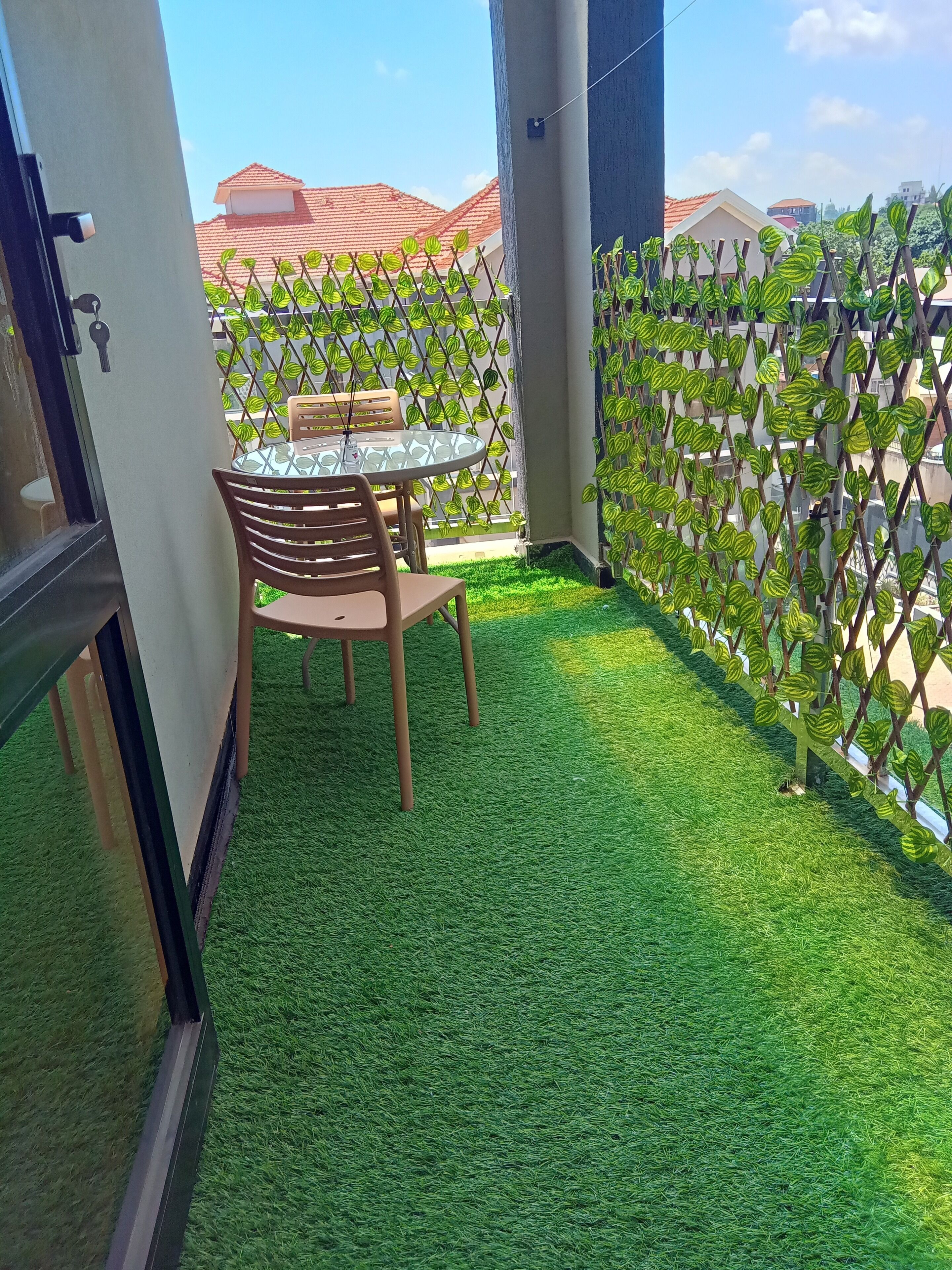 A balcony with artificial grass, a table, and chairs.