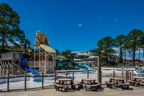 A water park with slides, picnic tables, and a wooden play structure. - Tidewater 406 | New Listing! Gulf Front Views |Walk to Pier Park (Panama City Beach)