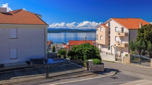 A coastal residential area with a clear view of the sea, a stone wall, and a paved road. - Quiet apartment with pool, terrace and parking in Crikvenica (Crikvenica)