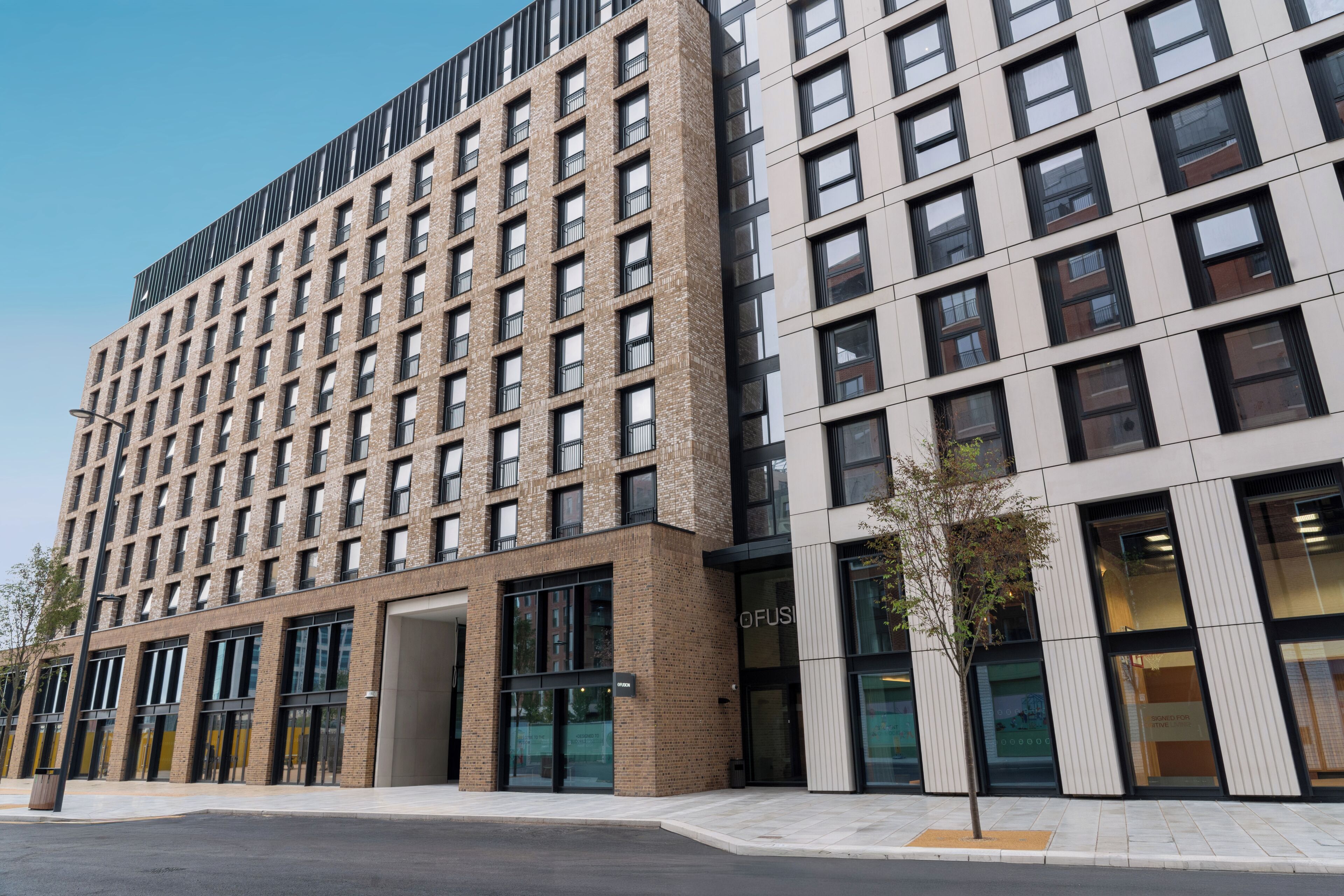 A multi-story building with a modern architectural style, featuring a mix of brick and glass facades, large windows, and a flat roof.