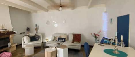 A living room with a sofa, coffee table, and a dining area with a table and chairs.