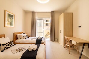 A hotel room with two beds, a desk, and a view of the outside. - Casa Elana Holiday Gozitan Home (Xaghra)