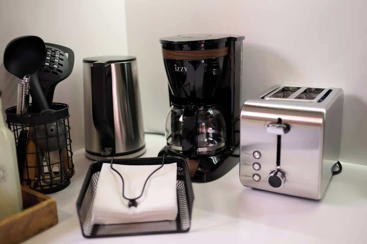 A kitchen with a coffee maker, toaster, and a black spatula in a holder.