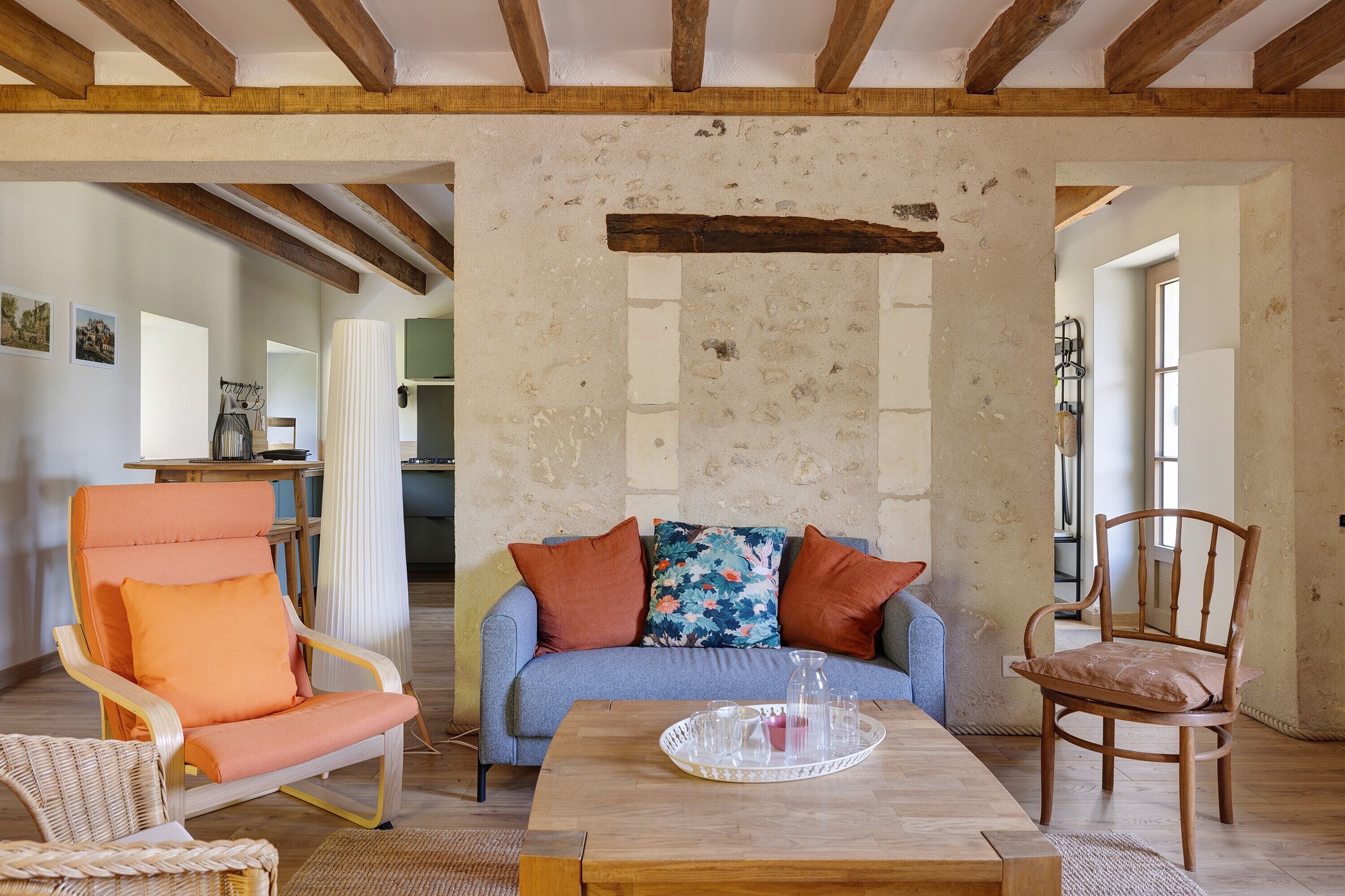 Una sala de estar con techo de madera, un sofá, un sillón y una mesita de centro.