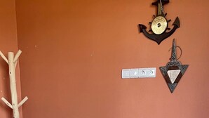 A room with two beds, a wooden coat rack, a wall clock, and a small table with a lamp. - Tremendous 4-bedroom bed & breakfast in tranquil Imi Ouaddar (Imi Ouaddar)