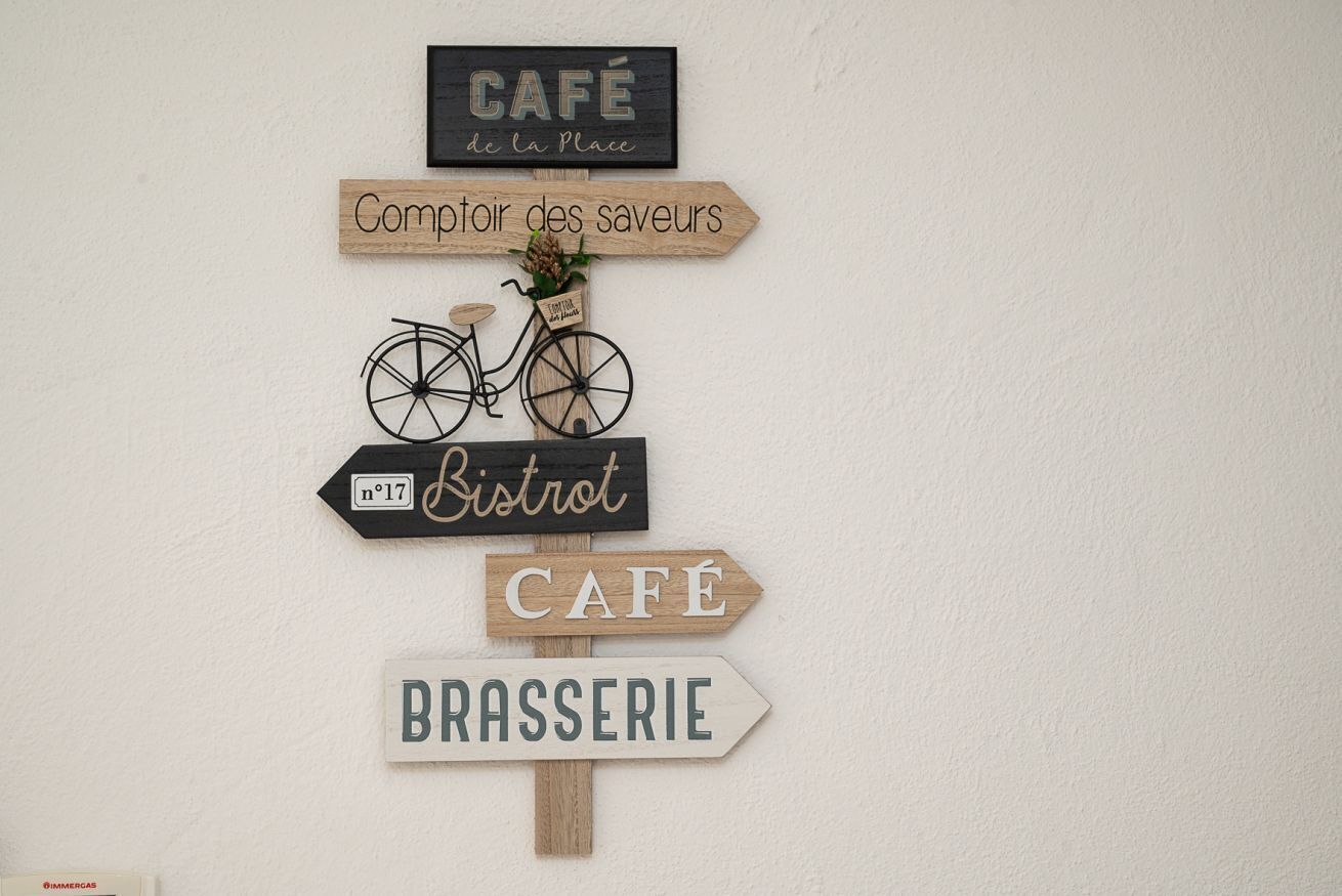 A wall with directional signs for a café, a bistro, and a brasserie.