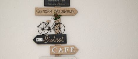 A wall with directional signs for a café, a bistro, and a brasserie.