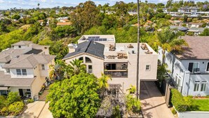 A residential area with houses, solar panels, and lush greenery. - Mission Bay Canyon House | Spanish View Retreat (San Diego)