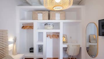 Ein Schlafzimmer mit Bett, Schreibtisch, Stuhl, Kleiderschrank, Spiegel und einer Pendelleuchte.
