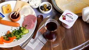 A table with various food items, drinks, and condiments. - Gold Senator Hotel (Baku)