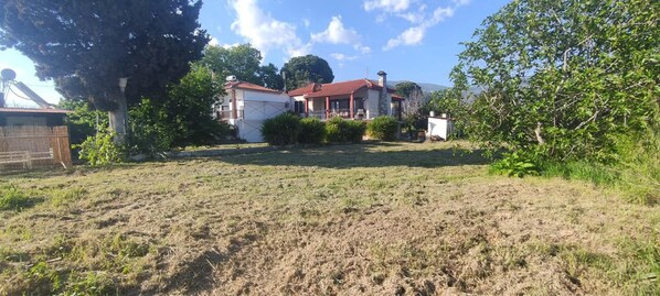 A residential area with houses, a grassy field, and trees.