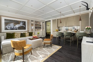 A modern living room with a sofa, chairs, a coffee table, and a dining area with a bar. - Dimora Elvezia Milano (Milan)