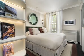 A neatly arranged bedroom with a large bed, a bedside table with books, a mirror, and a window with curtains. - Dimora Elvezia Milano (Milan)