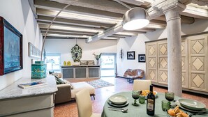 A dining area with a table set for two, a bottle of wine, and a bowl of bread. - La Loggetta Grand Canal San Marco (Venice)