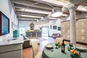A dining area with a table set for two, a bottle of wine, and a bowl of bread. - La Loggetta Grand Canal San Marco (Venice)