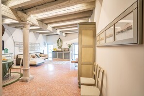 A spacious room with a high ceiling, exposed beams, a large window, and a view of the cityscape. - La Loggetta Grand Canal San Marco (Venice)