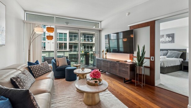 A modern living room with a sofa, coffee table, and a TV.