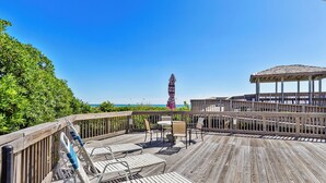 A wooden deck with outdoor seating, a gazebo, and a view of the ocean. - 1BR Condo w/ Pools, Balcony Views & Easy Beach Access | Pebble Beach (Emerald Isle)
