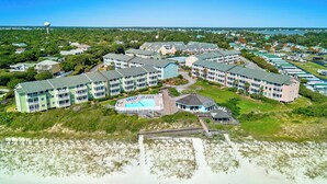 A coastal hotel with multiple buildings, a swimming pool, and a beach area. - 1BR Condo w/ Pools, Balcony Views & Easy Beach Access | Pebble Beach (Emerald Isle)