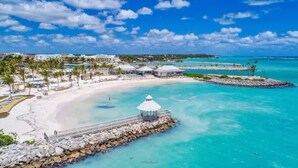 A beach resort with a gazebo, a pier, and clear turquoise waters.