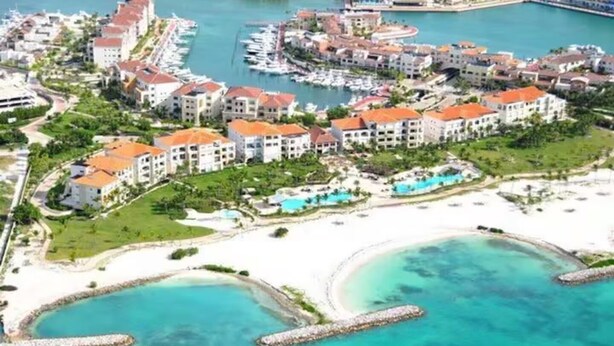 En kystresort med villaer direkte til stranden, en lysthavn og krystalklart turkis vand.