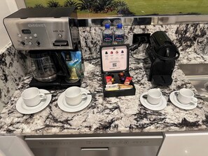 Eine Küche mit Cuisinart Espressomaschine, Kapselhalter und Wasserspender.
