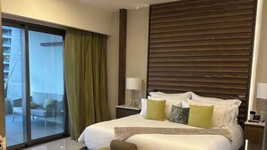 A hotel room with a large bed, a ceiling fan, a view to a balcony, and a modern design. - Luxury King bed + bath Junior Suite + kitchenette. 2 guest plus all inclusive. (Cancún)