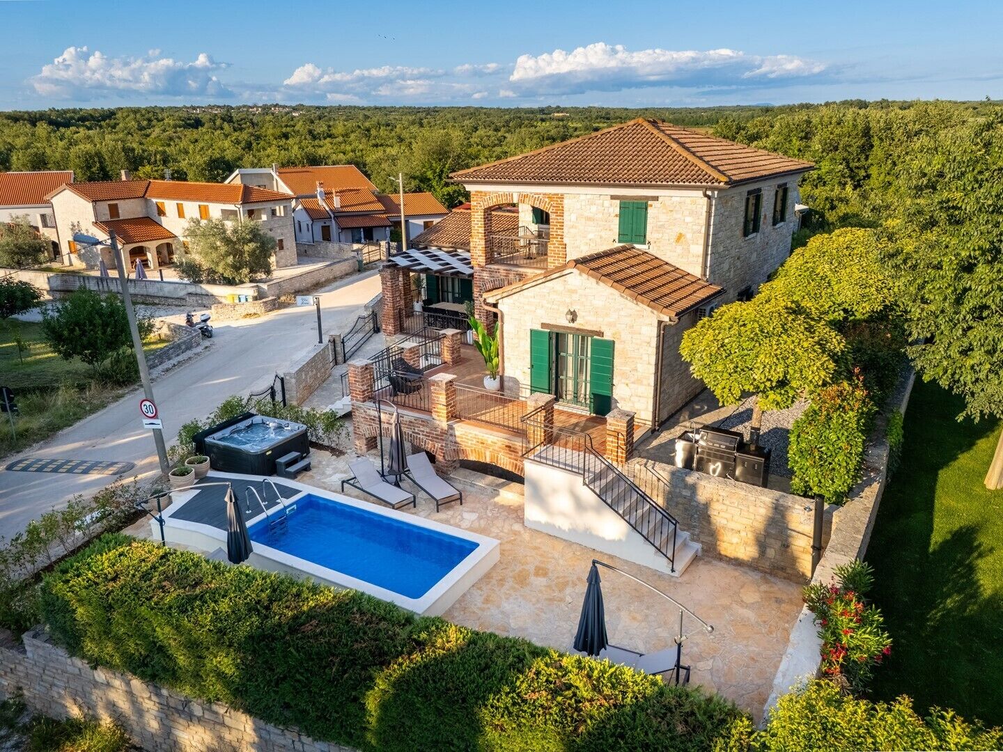 Uma villa com piscina, área de estar externa e vista para a paisagem ao redor.