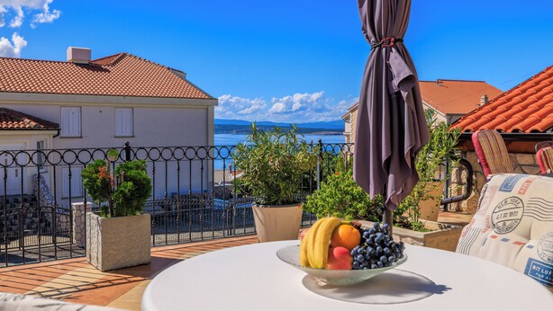 A balcony with a table, potted plants, and a fruit bowl. - Charming apartment with pool and parking in Crikvenica (Crikvenica)