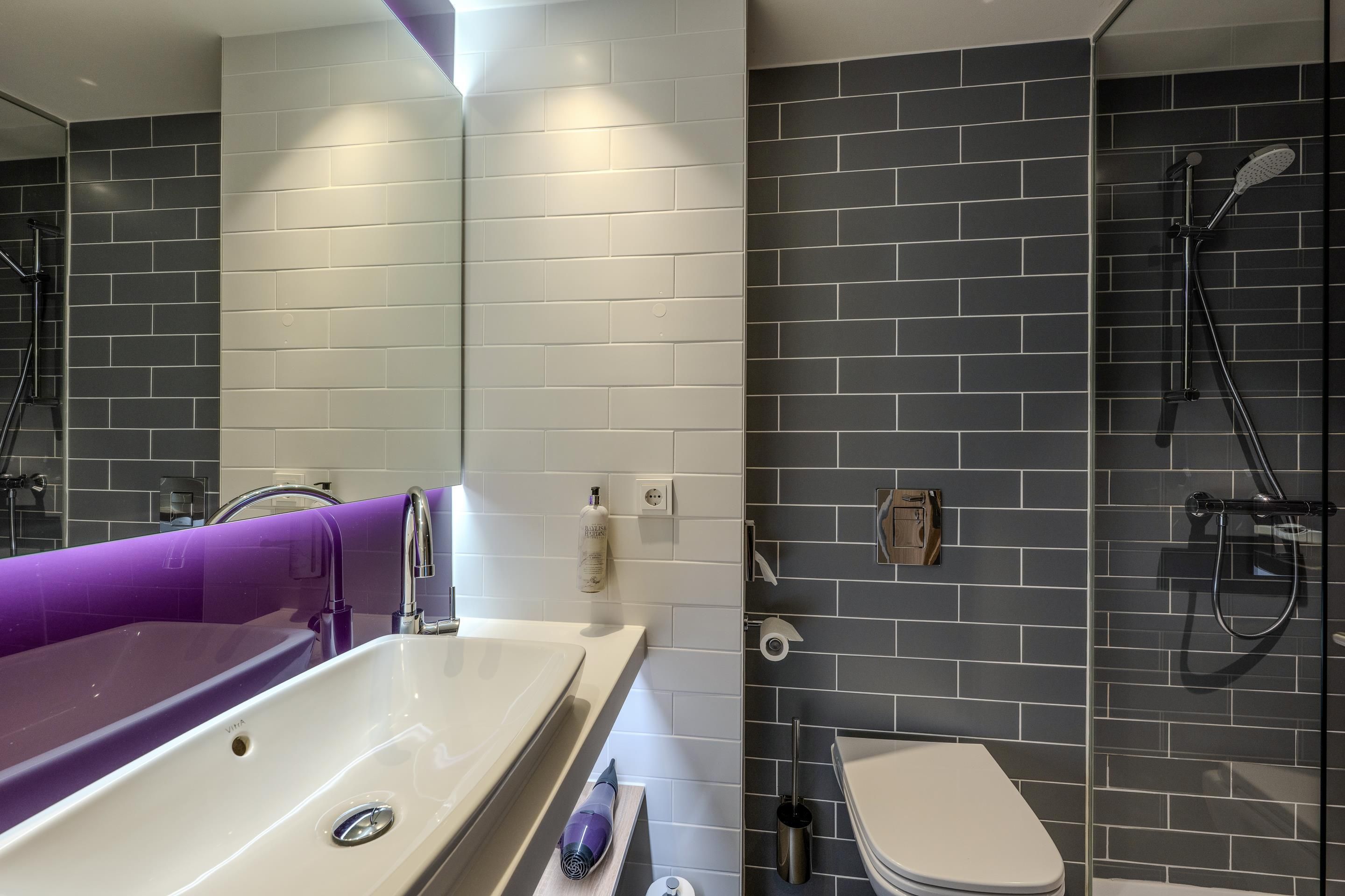Ein modernes Badezimmer mit einer weißen Badewanne, einer Toilette und einer Duschkabine.