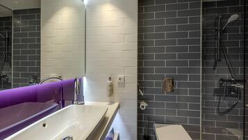 Ein modernes Badezimmer mit einer weißen Badewanne, einer Toilette und einer Duschkabine.